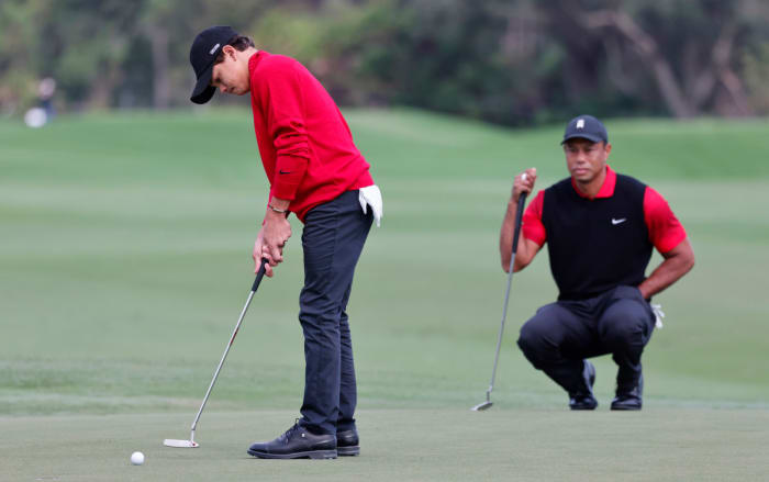 Dec 18, 2022; Orlando, Florida, USA; Charlie Woods (left) rolls a putt on the second hole as father Tiger Woods looks on during the final round of the PNC Championship golf tournament at Ritz Carlton Golf Club Grande Lakes Orlando Course. Mandatory Credit: Reinhold Matay-USA TODAY Sports